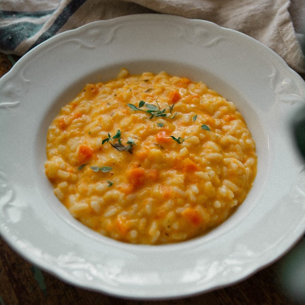a white plate topped with a bowl of macaroni and cheese